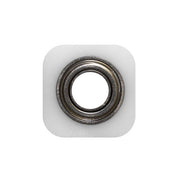 Metal bearing with white square backing block mounted on plain background.