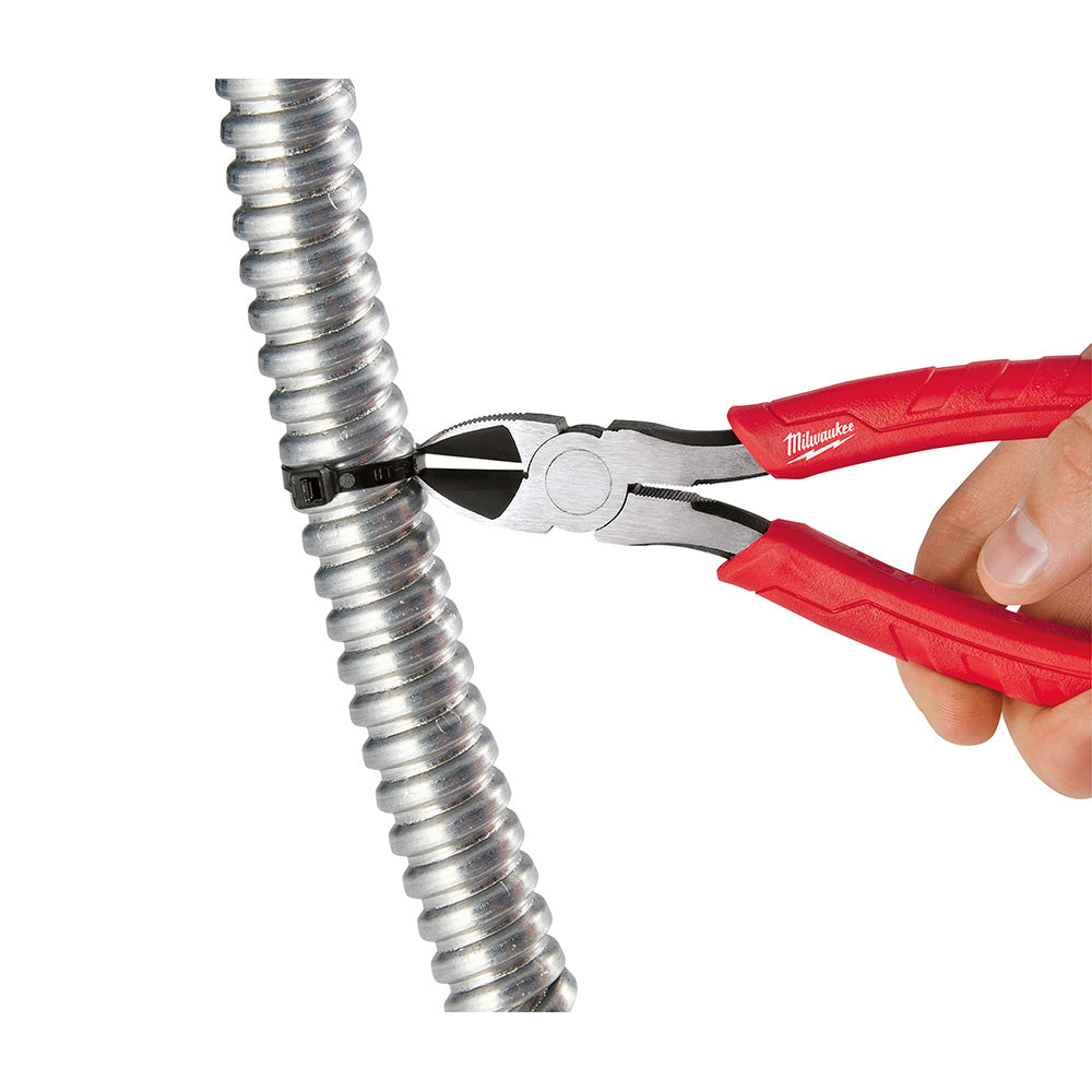 Diagonal cutting pliers with red handles cutting through a metal spring coil.