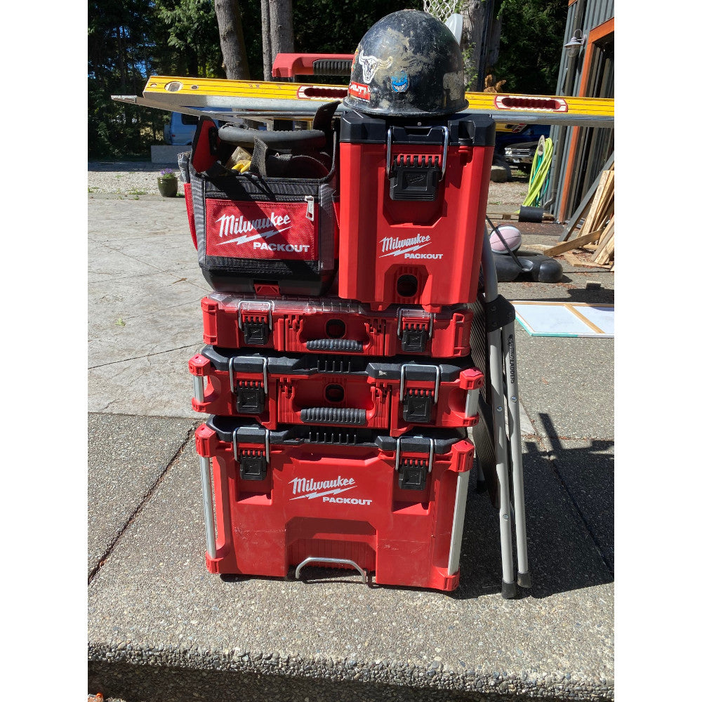 Red Milwaukee PACKOUT compact tool boxes stacked vertically with black handles and latches.