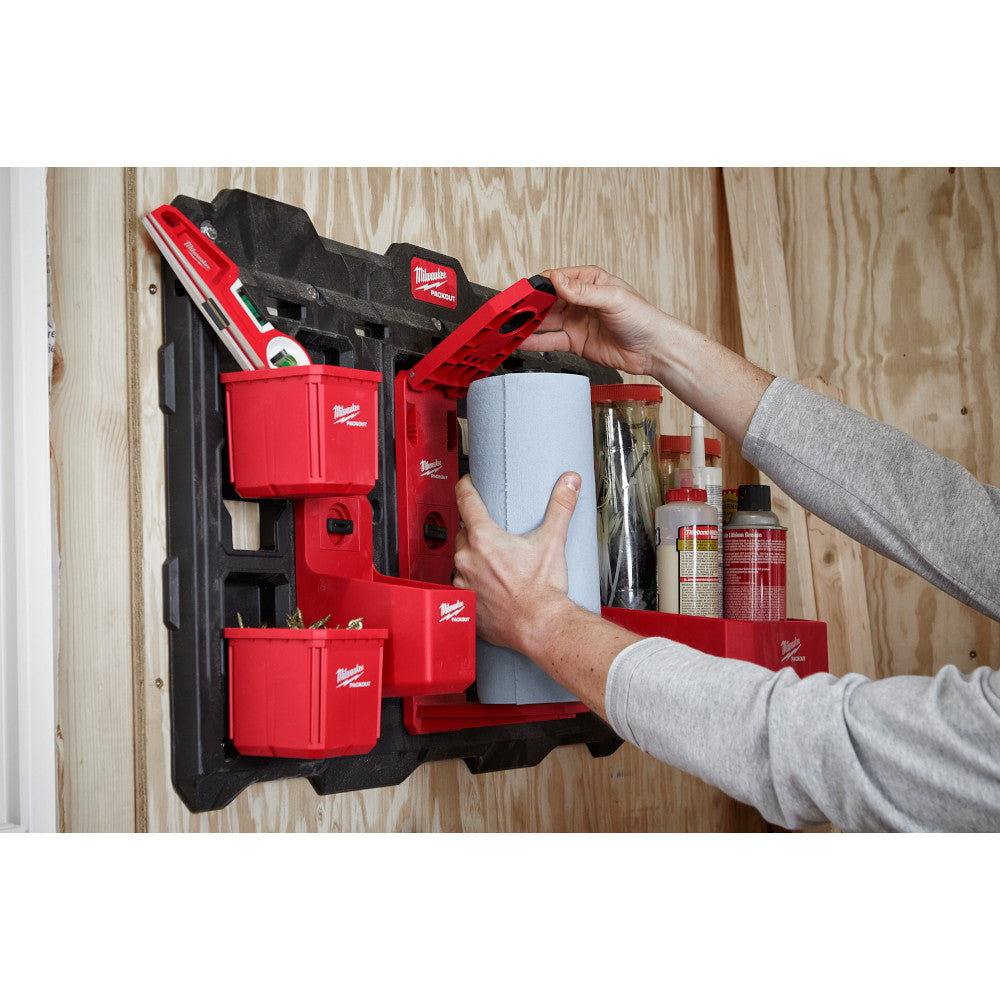 Red and black Milwaukee PACKOUT wall-mounted organizer with paper roll holder and storage compartments mounted on wooden wall