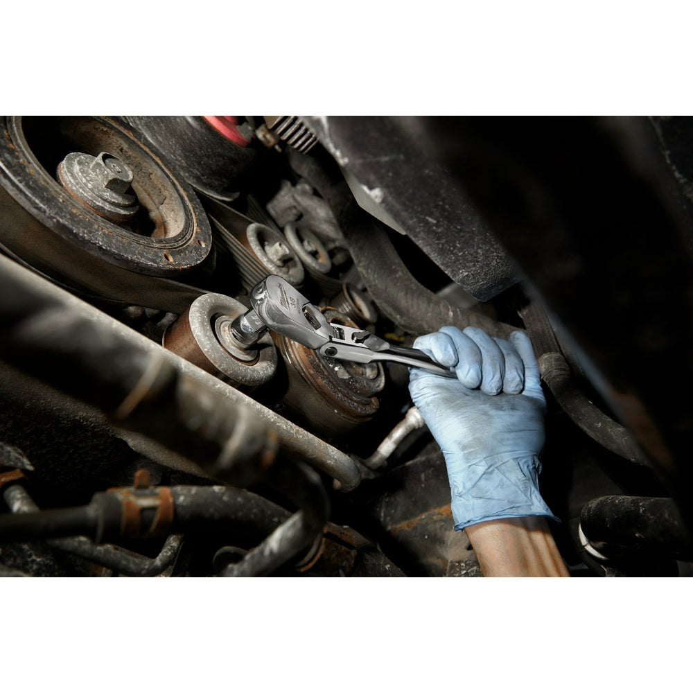 Metal flex head ratchet with 3/8" drive being used on vehicle suspension component by hand in work glove.
