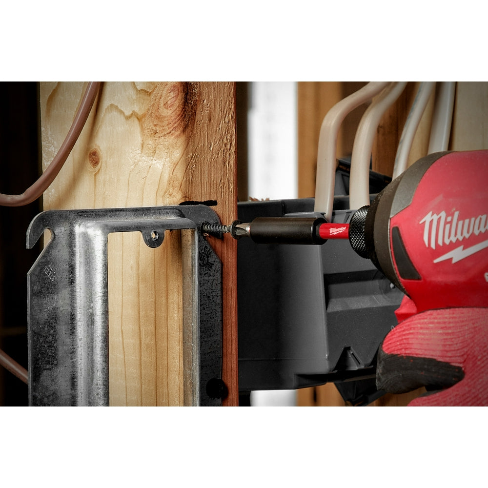 Black magnetic bit holder with red tip installed in Milwaukee drill driving screw into wood.