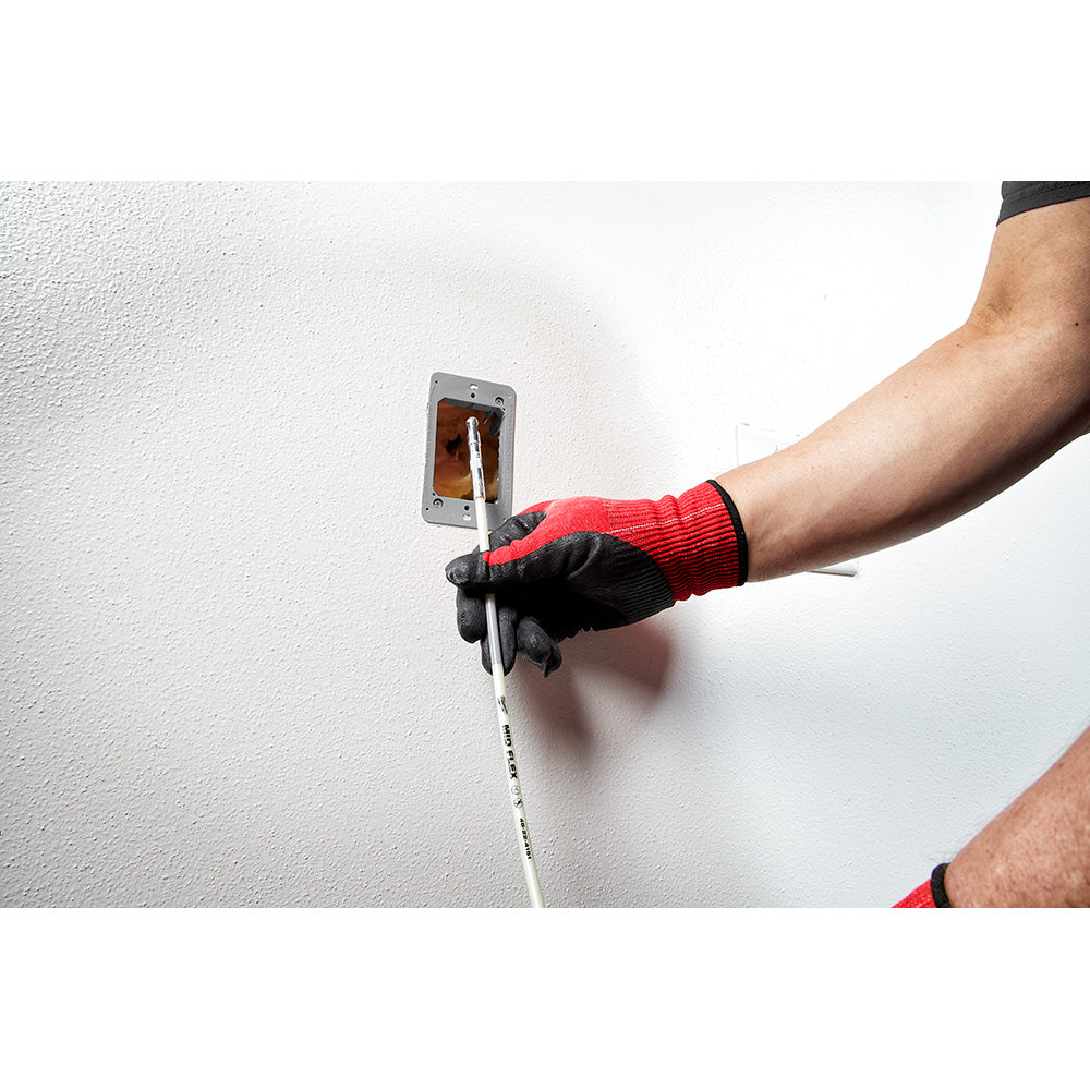 White flexible fish stick being used to route cable through wall outlet opening.