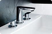 Chrome widespread bathroom faucet with two handles and curved spout mounted on white sink basin.