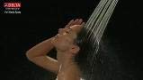 Chrome shower head with four spray settings mounted on wall with water flowing over person's shoulder.
