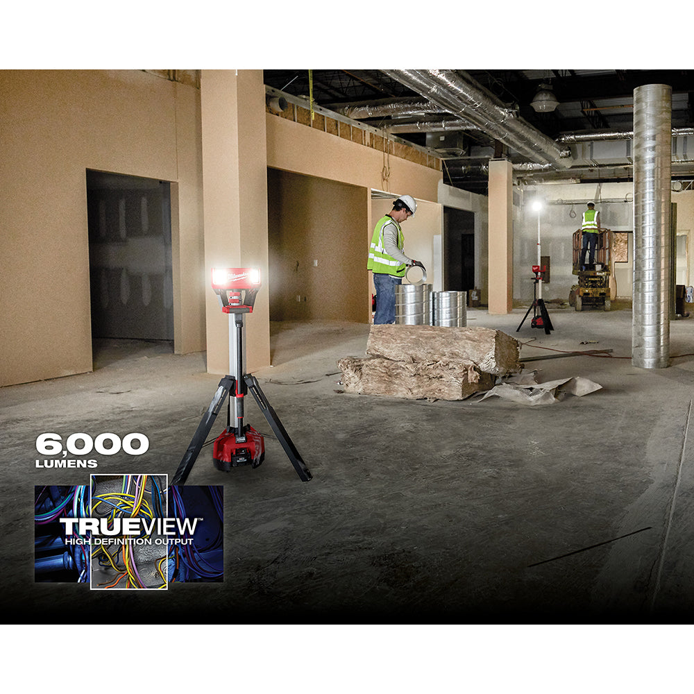 Milwaukee M18 ROCKET tower light with tripod stand illuminating a construction site interior.