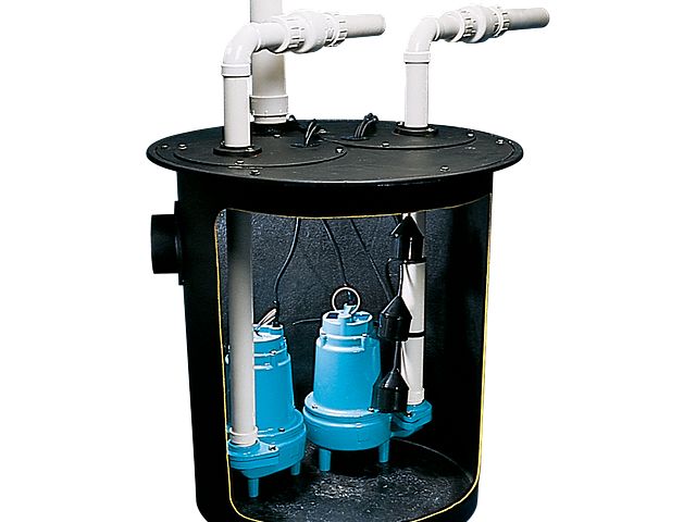 Black sump pump basin with two blue submersible pumps, white discharge pipes, and float switches inside.