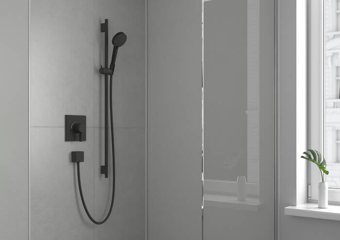 Matte black square pressure balance shower trim with handheld showerhead and wall-mounted controls installed in shower enclos