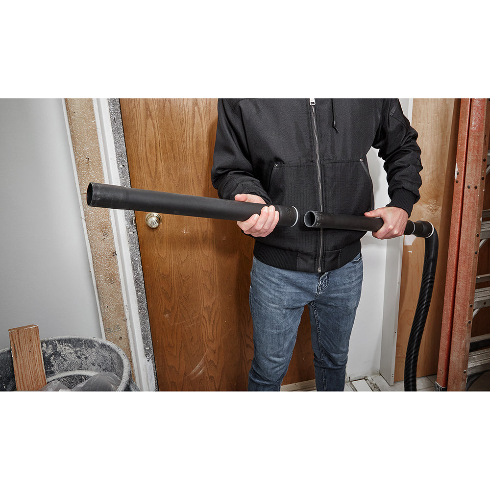 Black metal extension wand with grip handles held horizontally by person in black jacket.