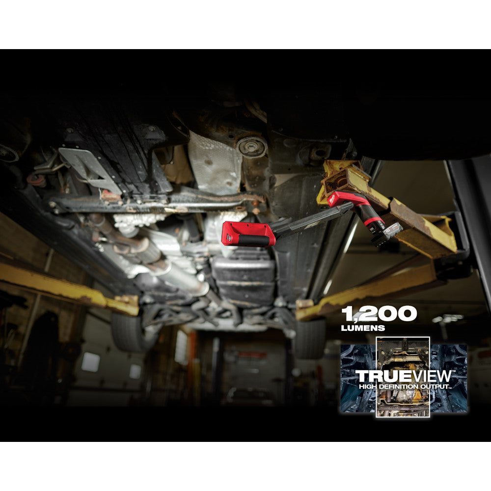 Milwaukee M12 underbody light mounted on vehicle undercarriage, illuminating engine components.