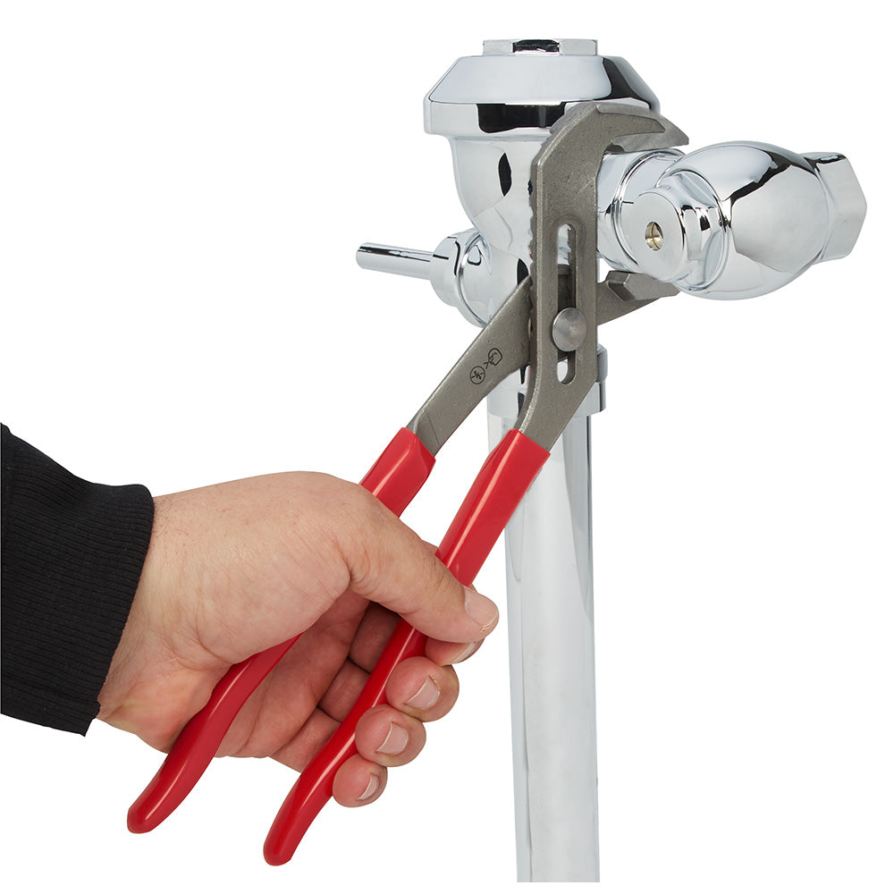 Milwaukee 12-inch smooth jaw vise held in a hand with red handles and metal clamping mechanism.