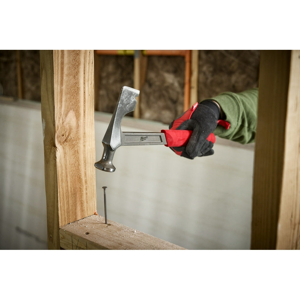Drywall hammer with flat striking head and nail puller, held in gloved hand above wooden framing.