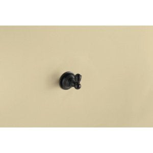 Moen wall-mount robe hook in brushed nickel finish with curved hook arm mounted on beige wall.