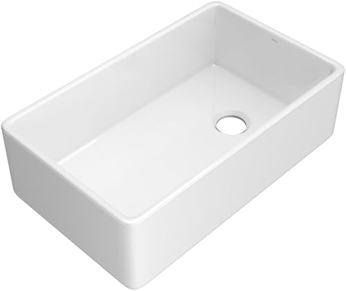 White fireclay farmhouse apron front kitchen sink with single bowl and drain hole.