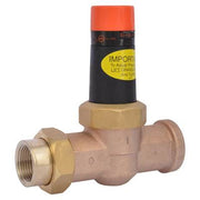 Brass pressure reducing valve with orange cap and yellow import label, 1 inch threaded inlet and outlets.