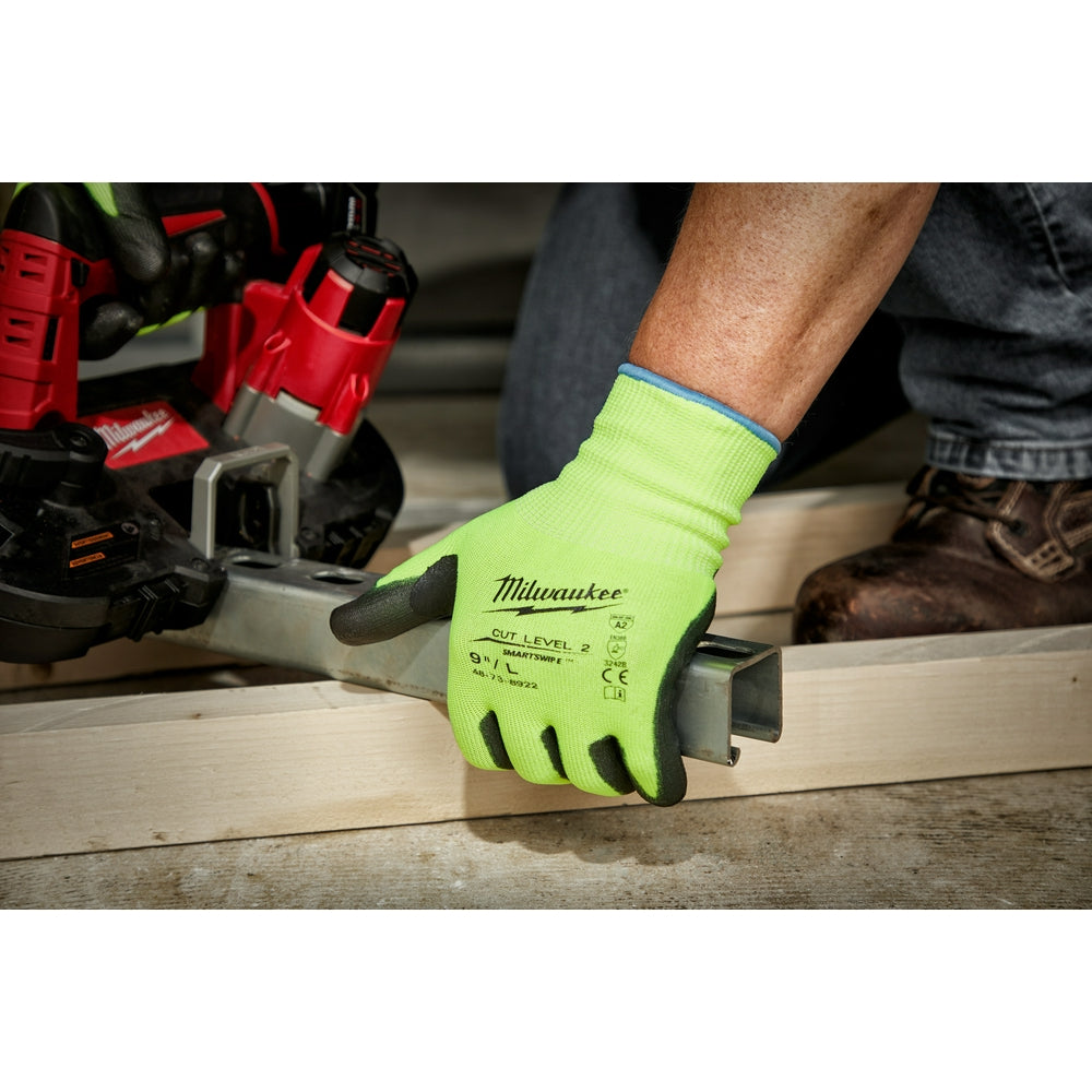 High-visibility yellow-green work glove with black polyurethane palm grip being worn while handling wood.