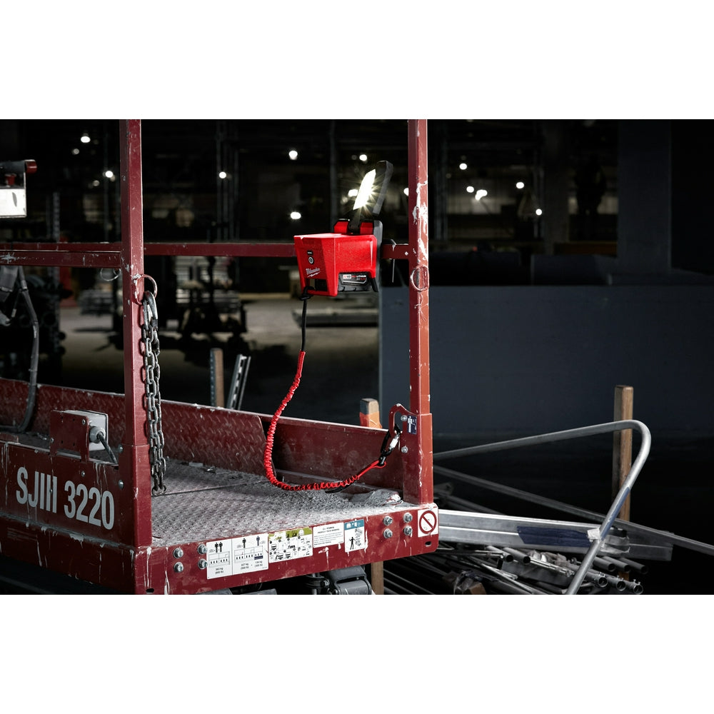 Red locking tool lanyard attached to red work platform with coiled cord and carabiner clip.