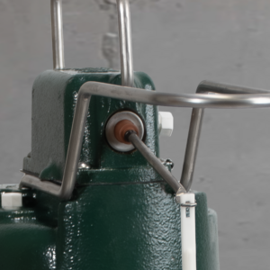 Green cast iron sewage pump with two metal handles on top and control lever on side.