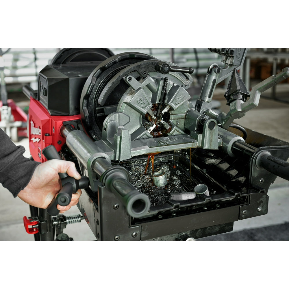 Dark cutting oil being applied to a threading machine during metal cutting operation.