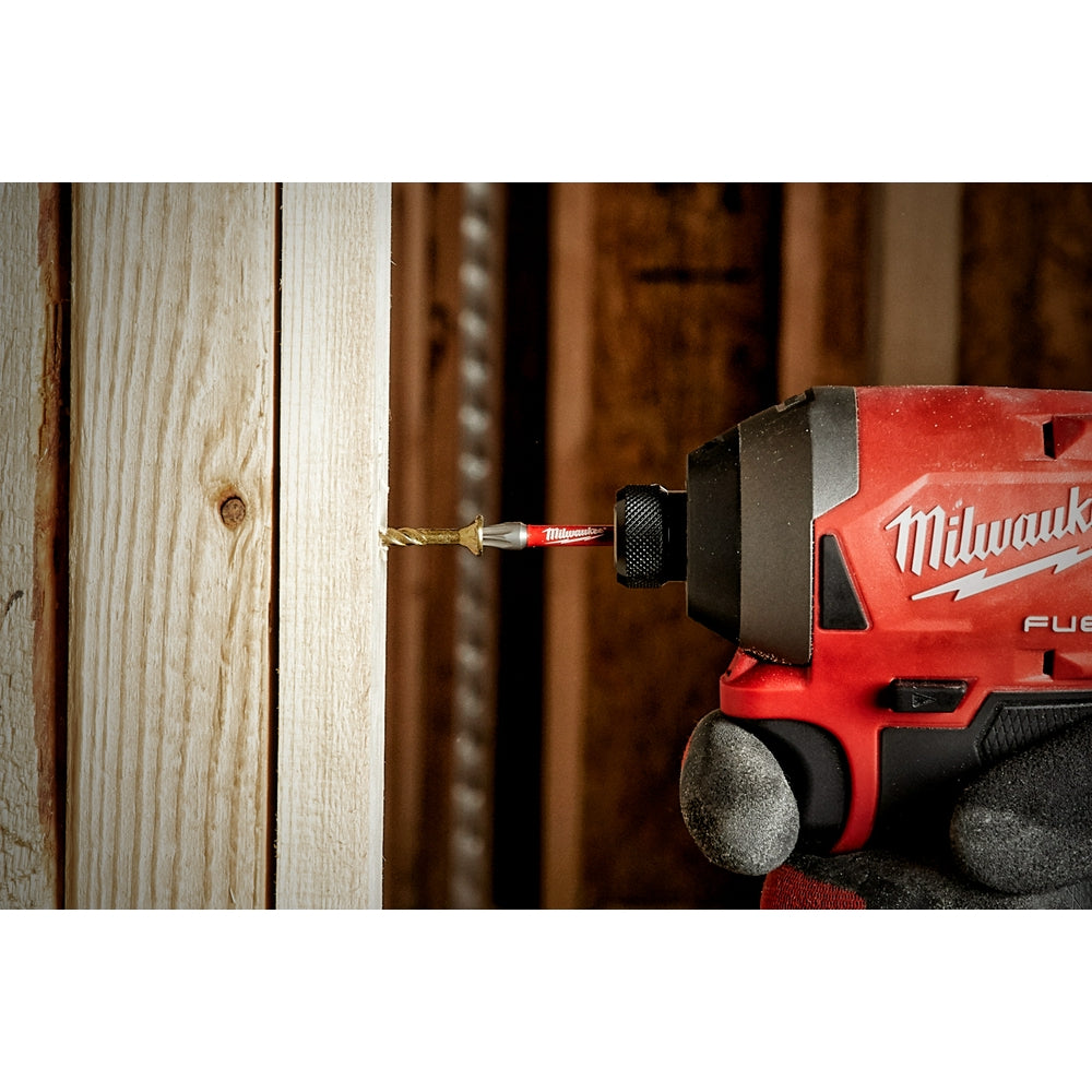 Milwaukee Shockwave Torx T30 impact power bit inserted in red drill driving into wooden surface.