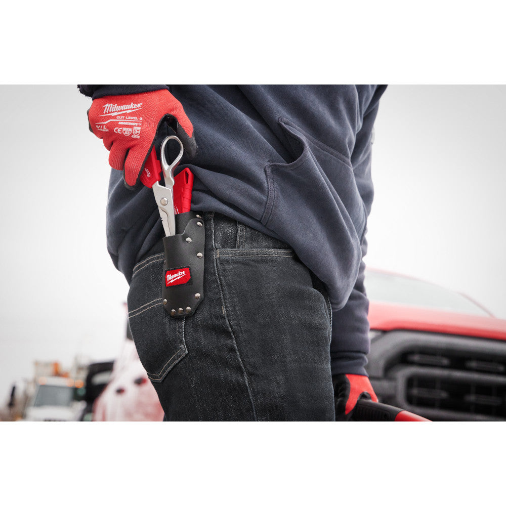 Black leather tool sheath with metal rivets and red Milwaukee branding, worn on work pants belt.