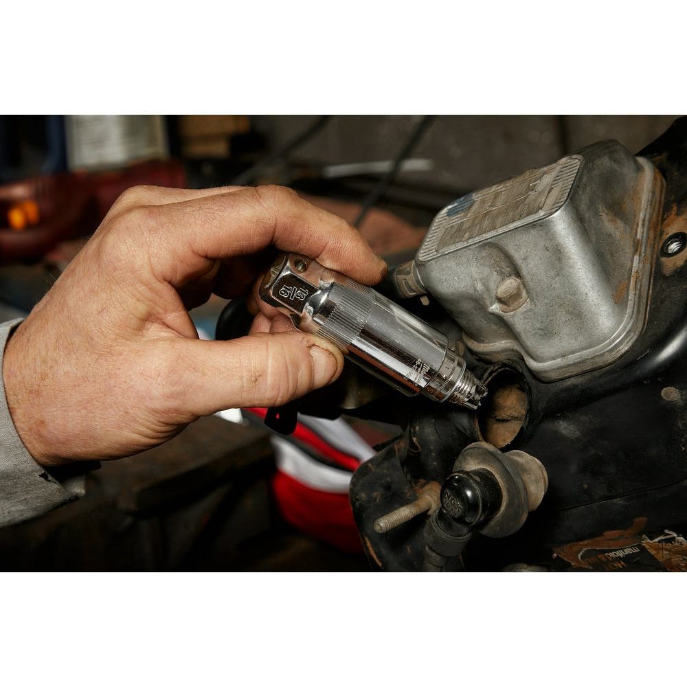 Milwaukee 3/8" drive 18MM spark plug socket held in hand during engine work.