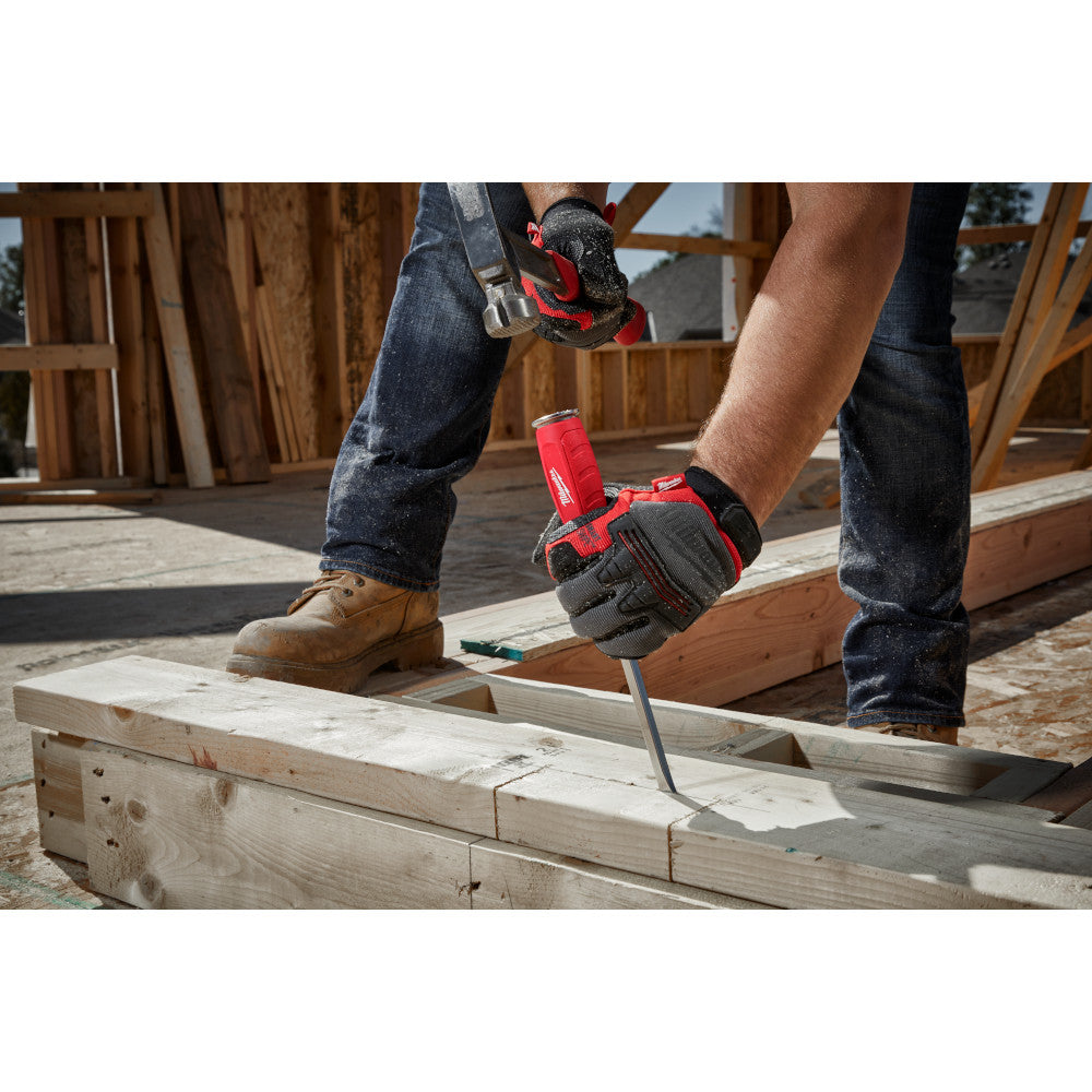 Worker in gloves using red and black demolition driver tool on wooden framing at construction site.