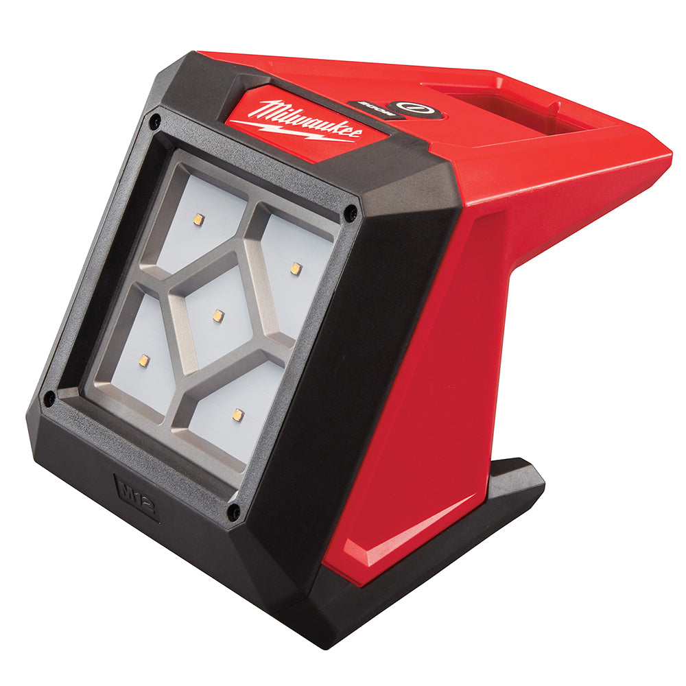 Milwaukee M12 compact flood light with red and black housing, LED grid front panel, and black rubber base.