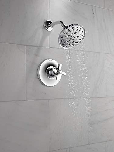 Chrome shower faucet with round showerhead and single lever control valve mounted on white tile wall.