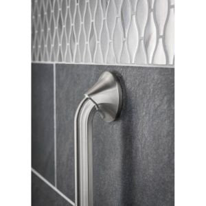 Stainless steel bathroom grab bar with curved design mounted on dark tiled wall.