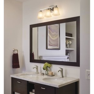 Brushed nickel wall-mount towel ring installed beside bathroom mirror above vanity.