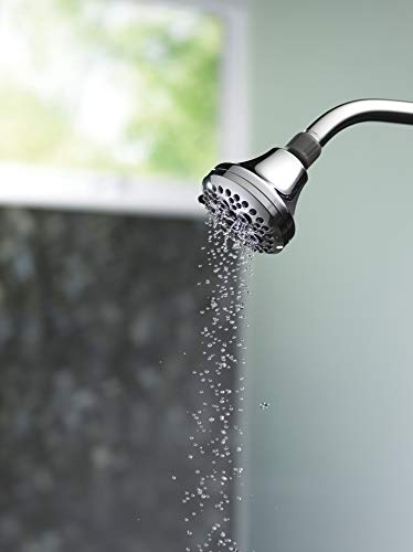 Chrome shower head with multiple spray holes dispensing water in a stream.