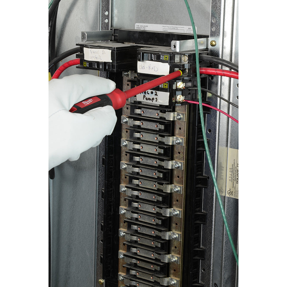 Red and black insulated screwdriver with non-slip handle being used in an electrical panel with circuit breakers.