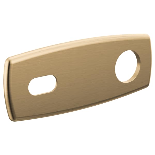 Brushed gold curved wall plate with one oval and one circular opening for lavatory fixtures.