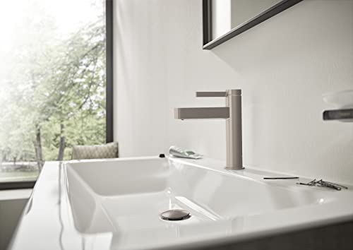 Brushed nickel single-hole bathroom faucet with cylindrical spout mounted on white sink basin.