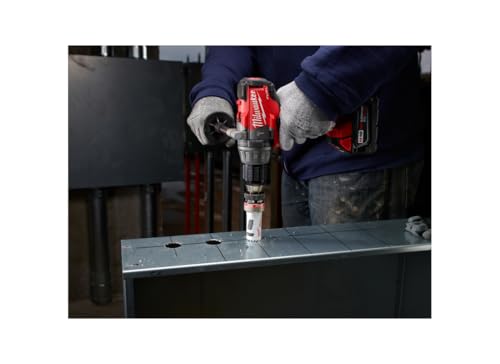 Milwaukee cordless drill with red hole saw bit drilling through metal sheet.