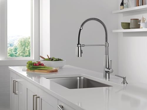 Arctic stainless steel soap and lotion dispenser with pump mechanism mounted on countertop next to sink.
