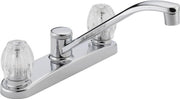 Chrome two-handle kitchen faucet with clear knobs and curved spout on white base plate.