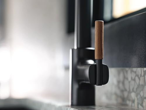 Matte black kitchen pulldown faucet with wooden accent handle mounted on countertop.