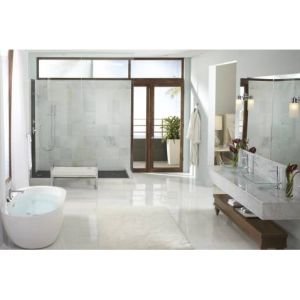 Brushed nickel shower trim kit mounted on bathroom wall above white bathtub with glass enclosure.