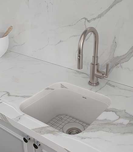 White fireclay single bowl bar sink with stainless steel faucet installed in marble countertop.