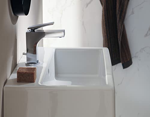 Chrome single-hole bathroom faucet with angular spout installed on white pedestal sink.