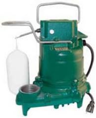 Green and gray Zoeller M57 submersible sump pump with handle and white collection basin attached.