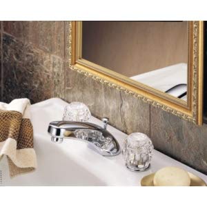 Chrome two-handle widespread bathroom faucet with crystal knobs and pop-up drain on white sink.