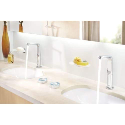 Chrome digital bathroom faucet controller with touchless sensor mounted on white backsplash above sink.