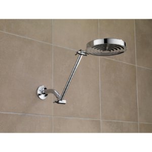 Chrome adjustable shower arm mounted on tiled wall with round showerhead and angled metal pipe.