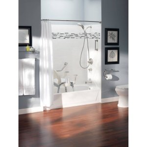 Bathroom shower enclosure with chrome grab bar and shelf mounted above tub fixtures.