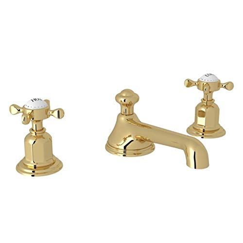 Unlacquered brass widespread lavatory faucet with low spout and cross handles.