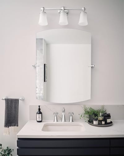Chrome two-handle widespread bathroom faucet with cross handles mounted on white sink countertop with mirror and vanity light