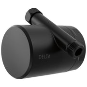 Matte black cylindrical shower filter attachment with threaded inlet and outlet ports, Delta branding visible on body.